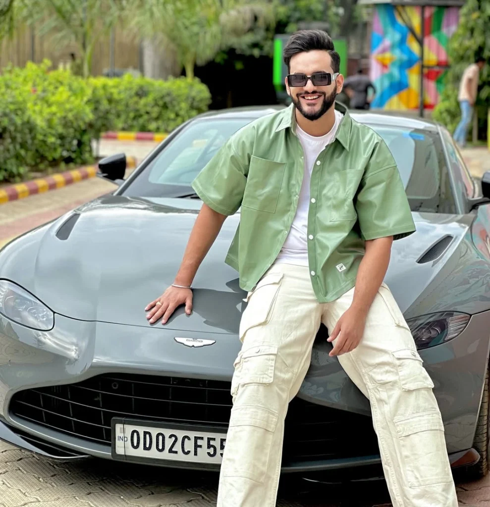 Abhishek Malhan posing with his luxury car, showcasing the high-end lifestyle and net worth of Fukra Insaan. Abhishek Malhan net worth