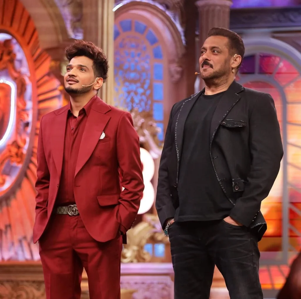 Munawar Faruqui triumphantly holding the Bigg Boss Season 17 winner trophy on stage.