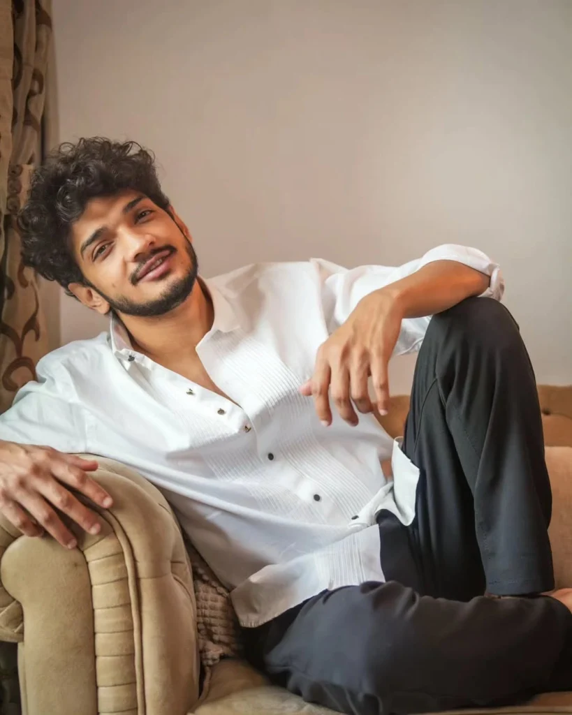 A stylish photograph of Munawar Faruqui posing with a luxury sports car, showcasing his lifestyle and net worth.