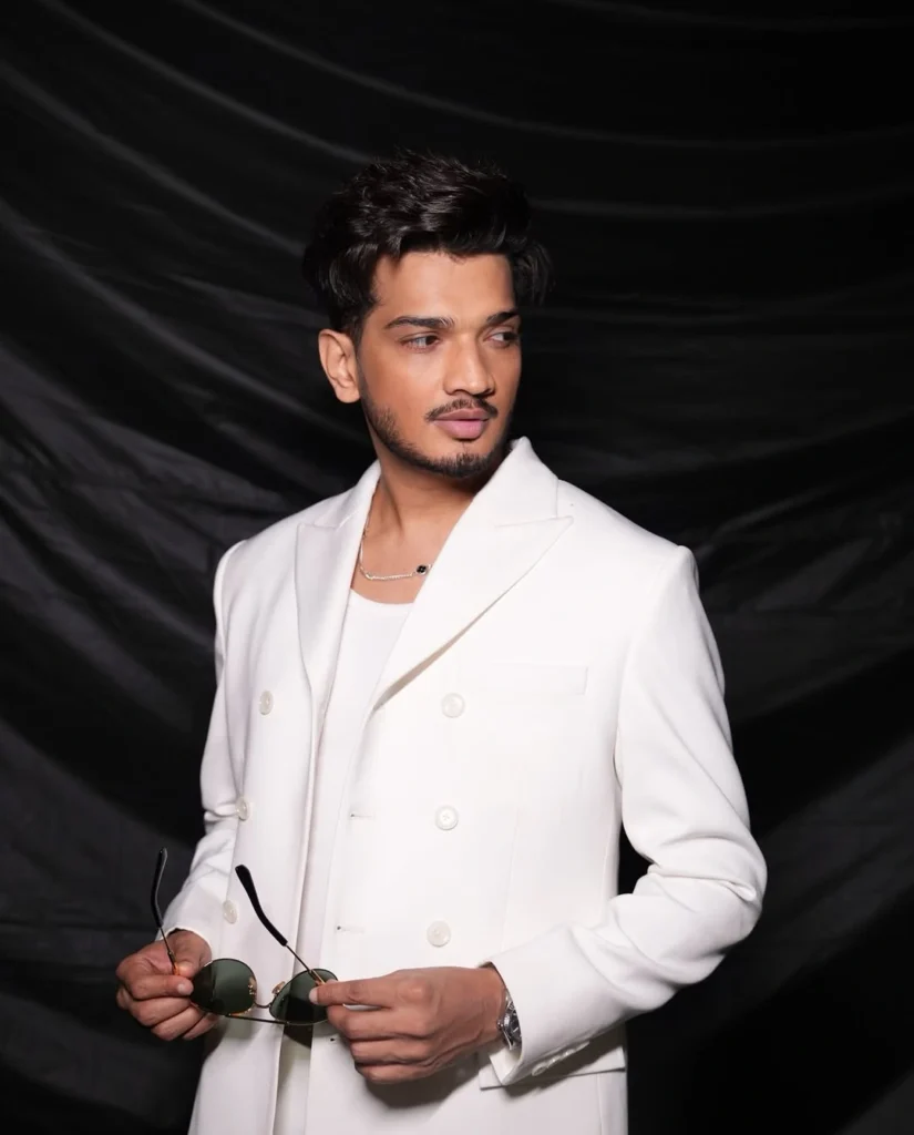 A dynamic image of Munawar Faruqui performing live stand-up comedy on a stage with a microphone.