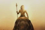 Dhanush in Vetri Maaran's Thamizh Murugan first look poster holding a sacred vel spear while riding an elephant in front of a massive army