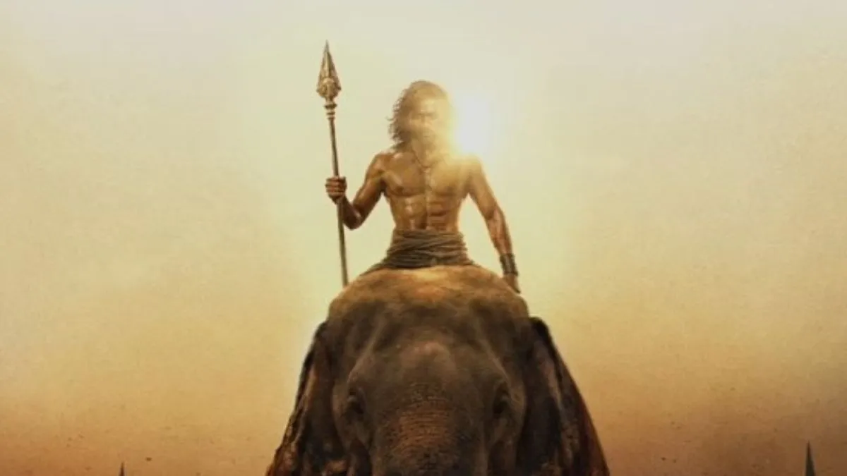 Dhanush in Vetri Maaran's Thamizh Murugan first look poster holding a sacred vel spear while riding an elephant in front of a massive army